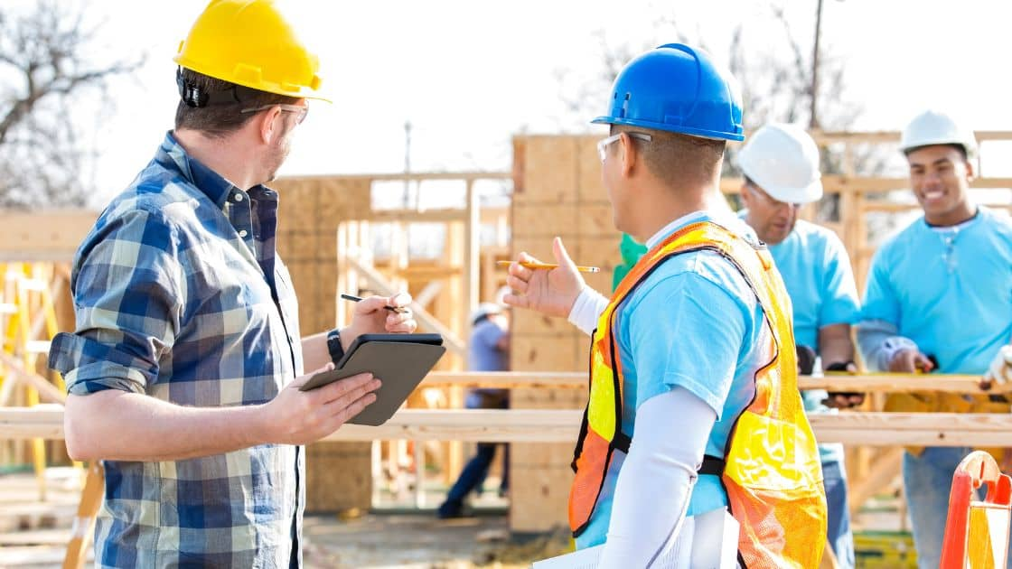 How to Plan a Successful Moving and Renovating Project 5 A family standing in front of their existing home, discussing the new construction